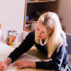 A children's counsellor helps a young girl working on a project